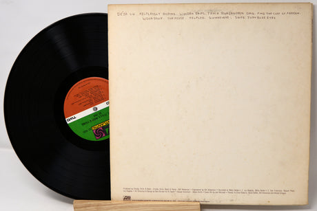 Vinyl record with a colorful label and its cover on a light background