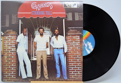 Vinyl record 'Crusaders Standing Tall' with cover featuring three men standing under a red awning.