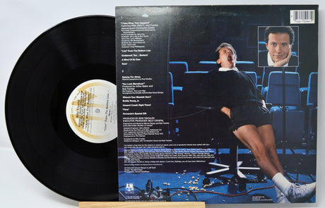 Vinyl record with a person lying on a couch and album cover art on the back