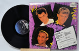 Vinyl record with a colorful cover featuring three men's faces on a purple background.