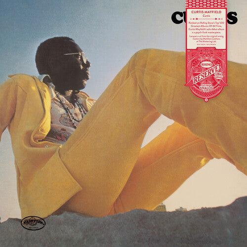 Curtis Mayfield sitting outdoors in a bright yellow suit, seen from a low angle, album cover for Curtis