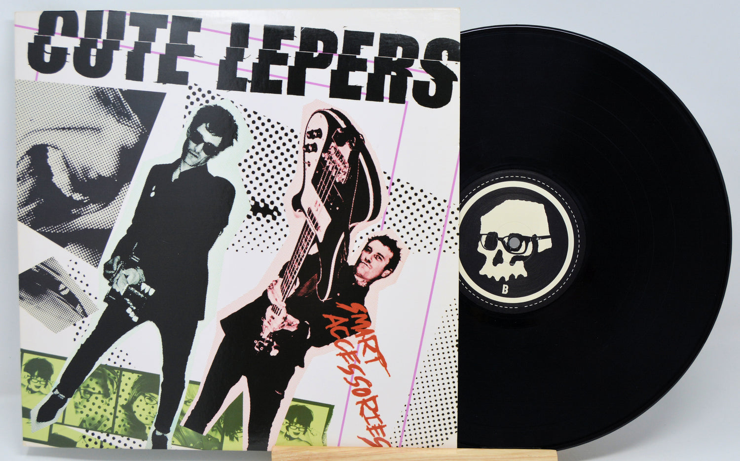 Vinyl record with a colorful cover featuring band members and a black record with a skull logo.