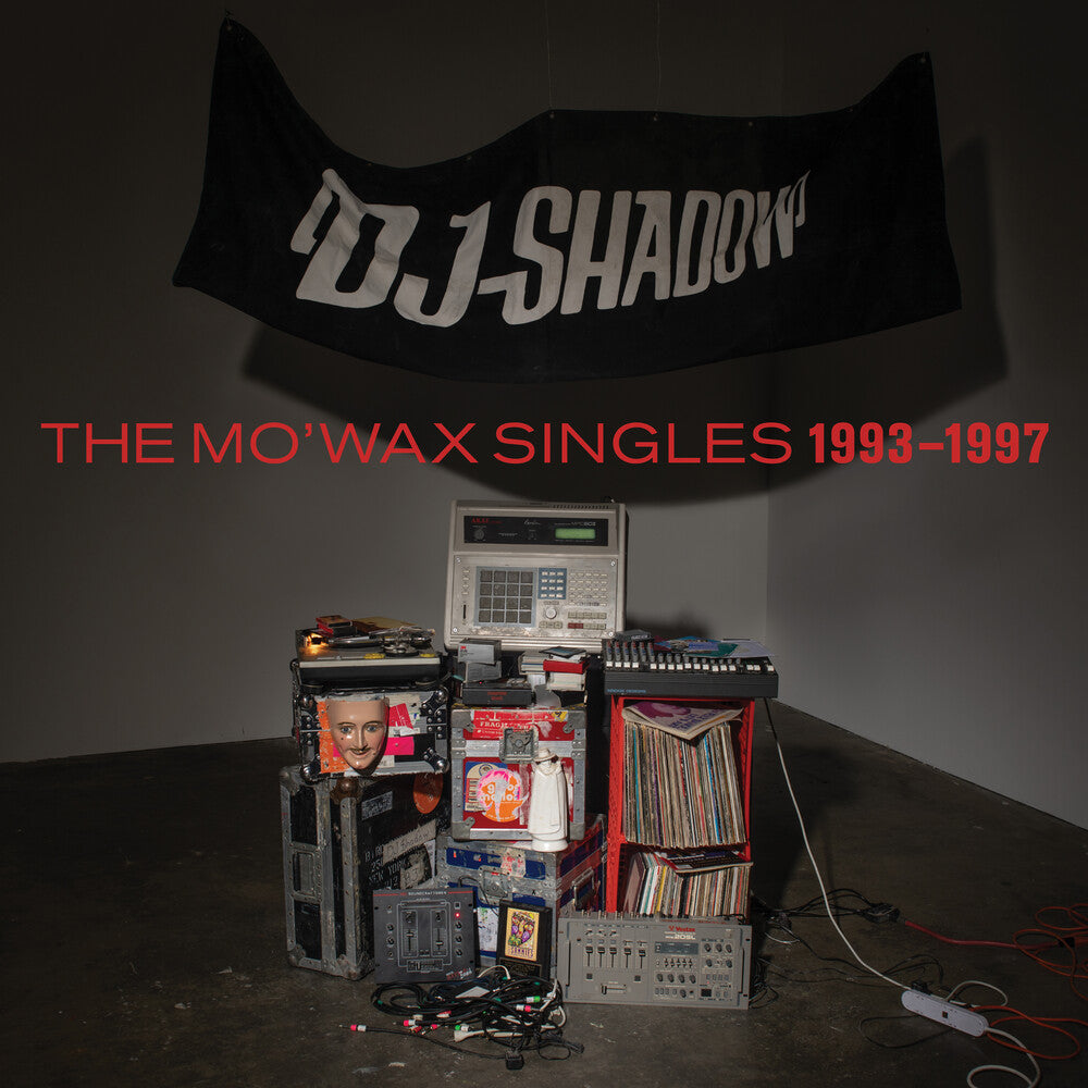 Album cover for 'The Mo'Wax Singles 1993-1997' by DJ Shadow with vinyl records and equipment.