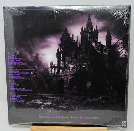 Vinyl record cover with gothic architecture and purple text on a dark background