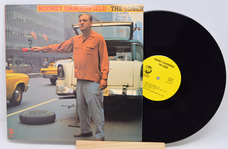 Vinyl record with cover featuring a man on a city street, yellow taxi in background