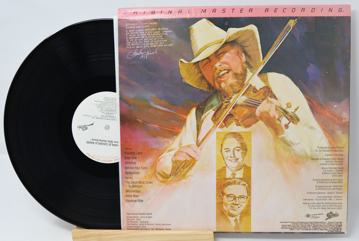 Vinyl record with cover featuring a person playing violin, on a light gray background