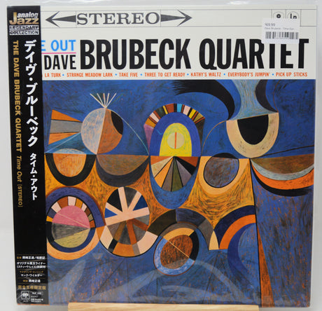 Dave Brubeck Quartet 'Time Out' LP album cover, showing a colorful abstract geometric design in blue, orange, black, and white, with the band name in large letters and a black spine band on the left.