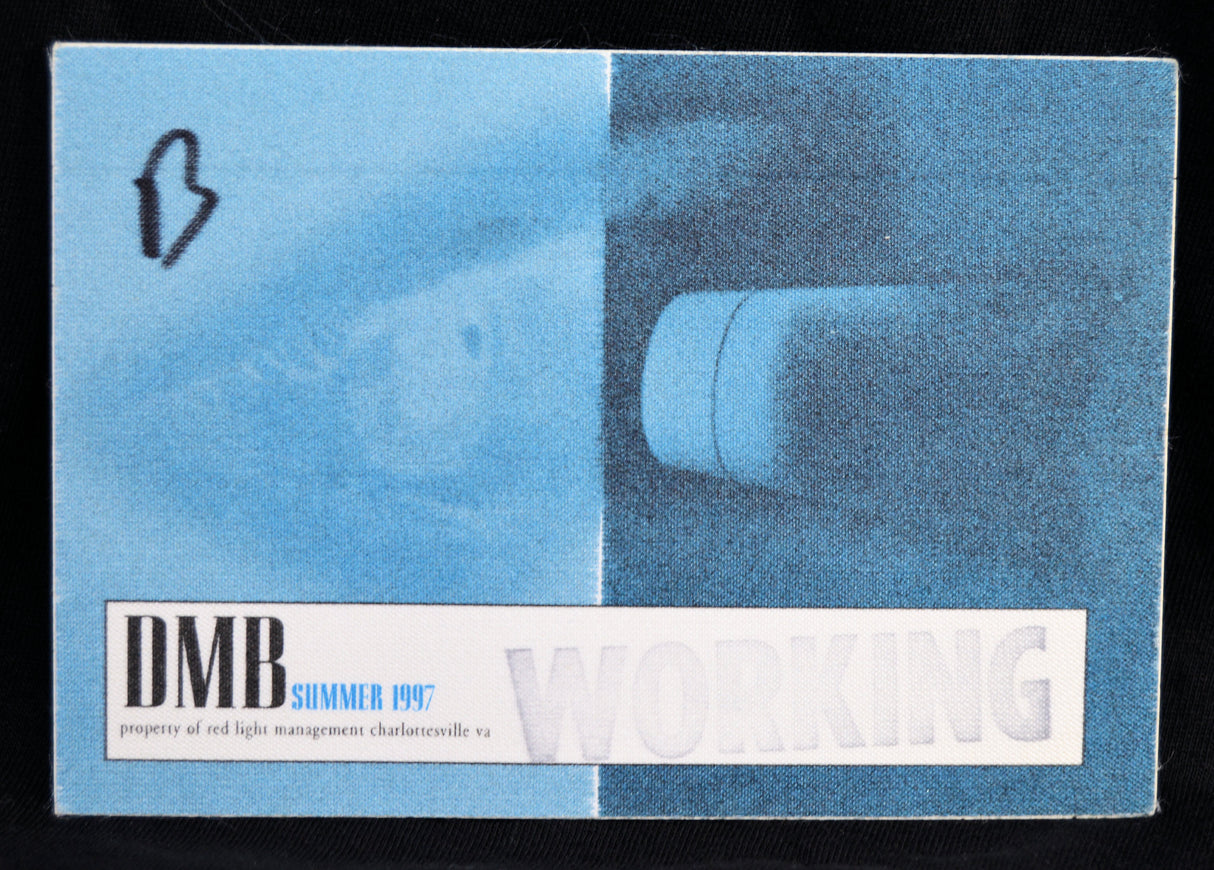 A vintage DMB Summer 1997 bbackstage pass for Working Property, featuring a blue and white design with a faint image of a light fixture.
