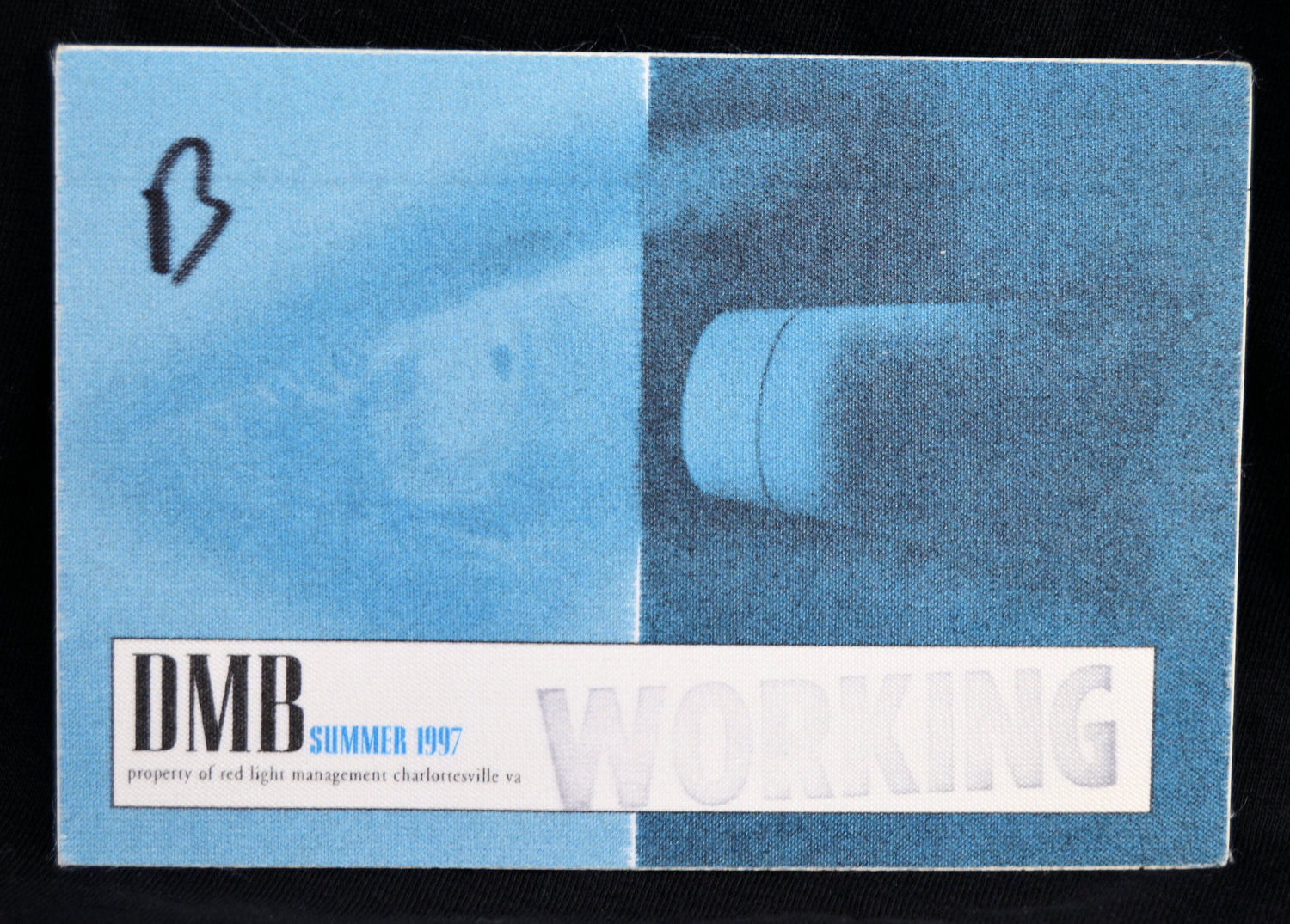 A vintage DMB Summer 1997 bbackstage pass for Working Property, featuring a blue and white design with a faint image of a light fixture.