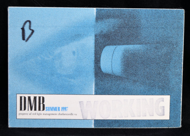 A vintage DMB Summer 1997 bbackstage pass for Working Property, featuring a blue and white design with a faint image of a light fixture.