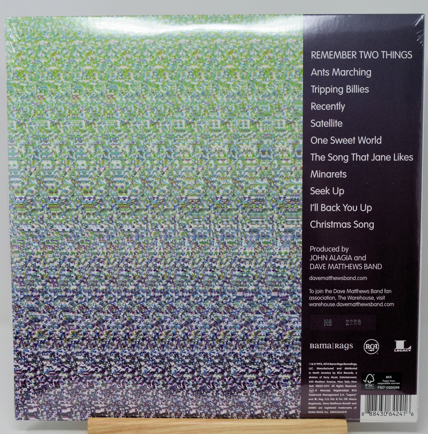 The back cover of a 12-inch vinyl record sleeve for Daftoon's album 'Remember Two Things', resting on a small wooden display block. The cover features a dense, multicolored pixelated pattern on the left and a black tracklist panel on the right.