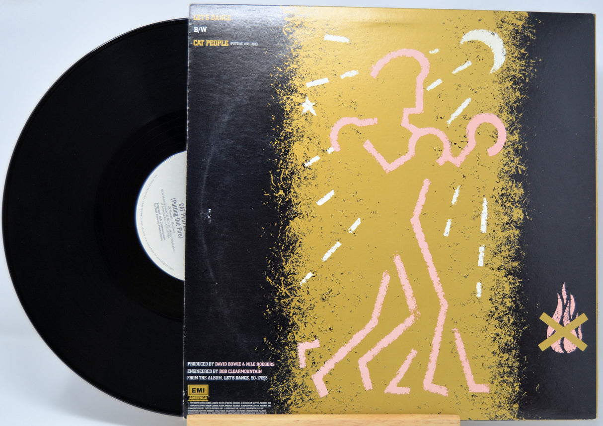 Vinyl record 'David Bowie Let's Dance 12 Inch' with a colorful cover featuring abstract designs on a light blue background