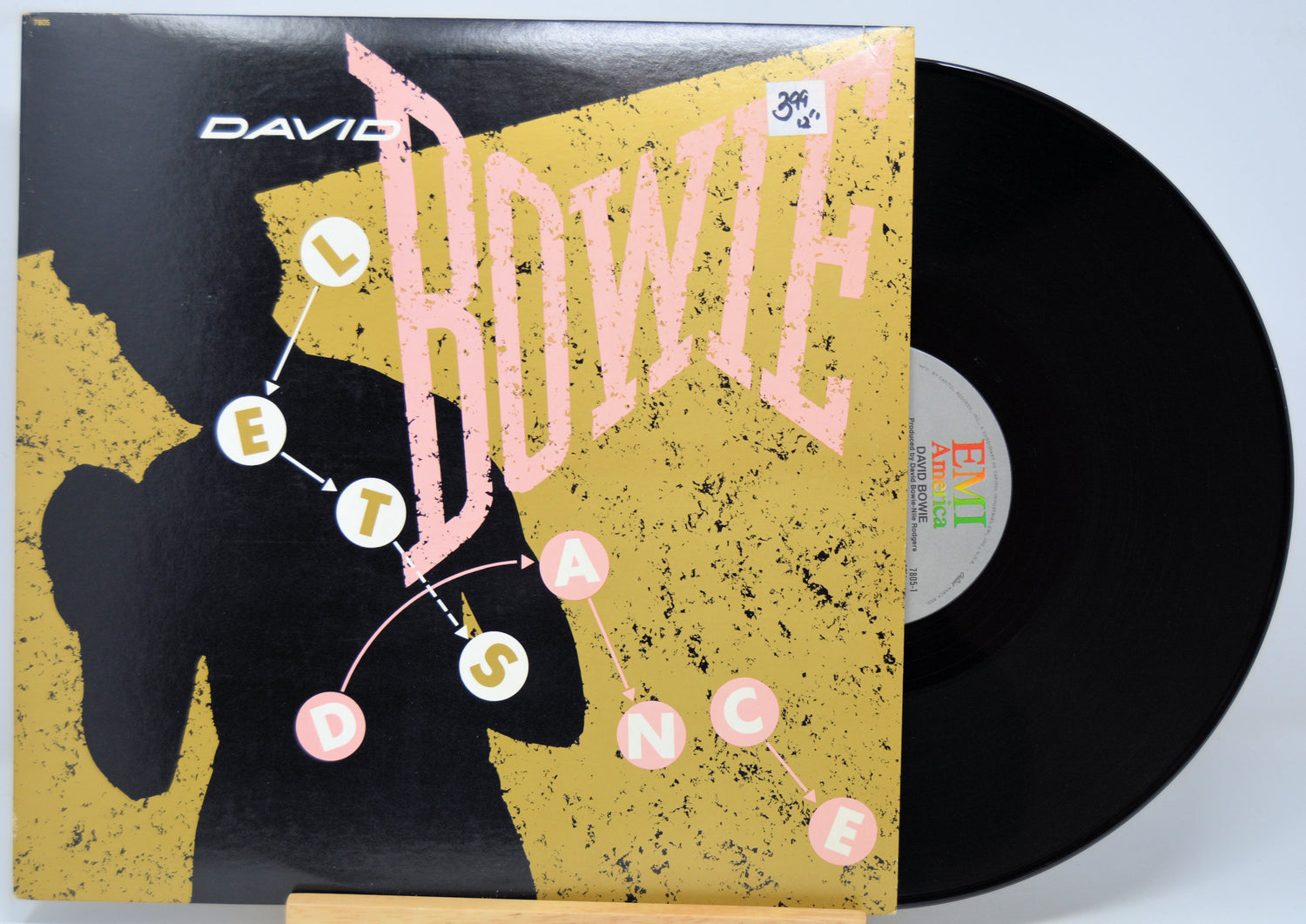 12 Inch Vinyl record with a cover featuring 'David Bowie Let's Dance' in pink text on a yellow background