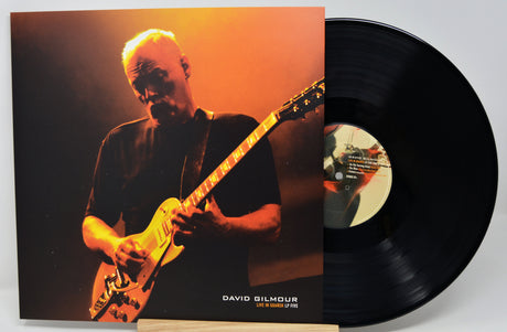 David Gilmour 'Live in London 27 June' vinyl record LP with the album cover in front and the black LP record partially visible behind it on a light gray background.