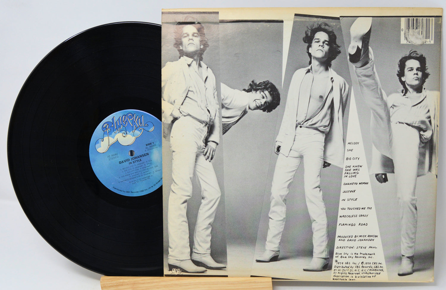 Vinyl record with a black label and a cover featuring a black and white photo of a person in a suit.