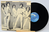 Vinyl record with a cover featuring a group of people posing.