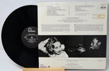 Vinyl record with cover featuring a black and white image of a woman and a man, with text on a light gray background.