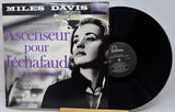 Vinyl record with Miles Davis album cover featuring a woman's face and text.
