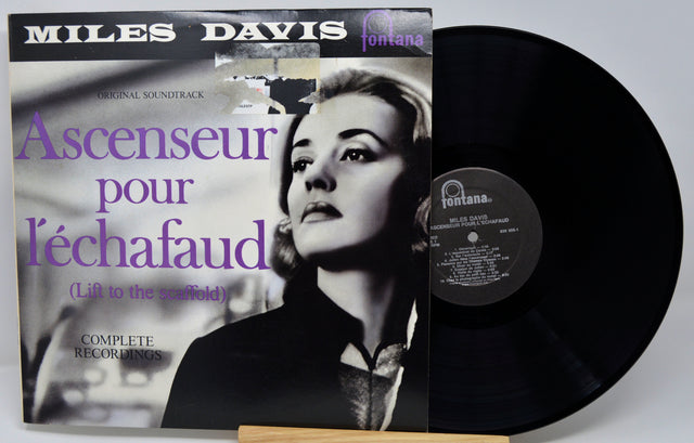 Vinyl record with Miles Davis album cover featuring a woman's face and text.