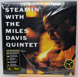 Steamin' With the Miles Davis Quintet vinyl record album in its original shrink wrap, displayed on a wooden stand. The cover art features a dramatic portrait of Miles Davis with a match, rendered in fiery orange and yellow tones against a black background, with white title text and a yellow 'Limited Edition' seal.