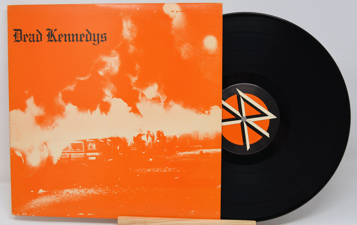 Vinyl record with orange cover featuring 'Dead Kennedys' and a black record with a logo.