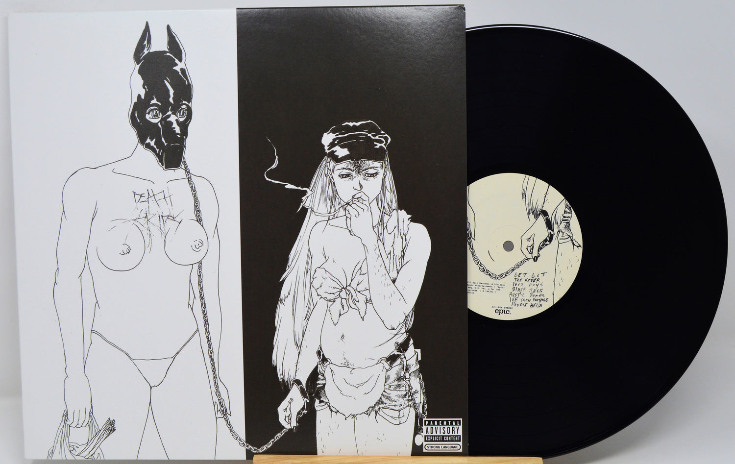 Vinyl record with artistic cover featuring black and white illustrations of a person and a mask.