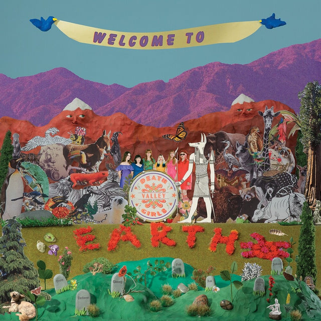 The album cover art featuring a highly detailed, colorful collage of various illustrated figures, animals, and landscapes. The scene includes a yellow banner reading 'WELCOME TO Earth', a large central drum with the text 'Death Valley Girls', and a green foreground with 'EARTH' spelled out in red flowers.