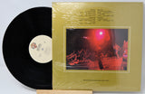 Vinyl record with a yellow cover featuring a concert image and text.