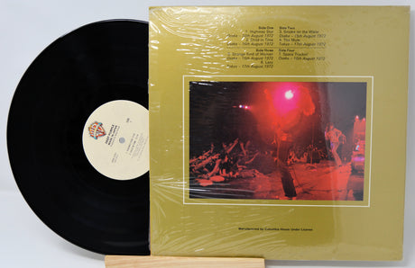 Vinyl record with a yellow cover featuring a concert image and text.