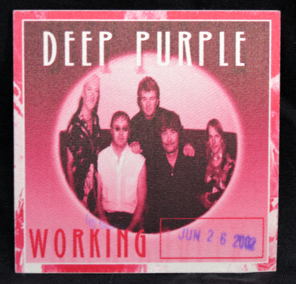 A square Deep Purple 'Working' backstage pass, featuring the band members in a circular frame with pink and red borders and text.