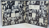 A black-and-white collage album book or photo album displayed open, filled with numerous small black-and-white portrait photographs, handwritten notes, and printed text panels.