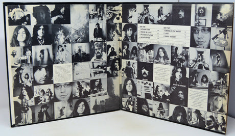 A black-and-white collage album book or photo album displayed open, filled with numerous small black-and-white portrait photographs, handwritten notes, and printed text panels.