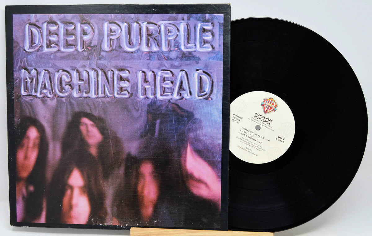 Deep Purple - Machine Head vinyl record shown with the album cover on the left and the black LP record partially pulled out on the right against a white background.