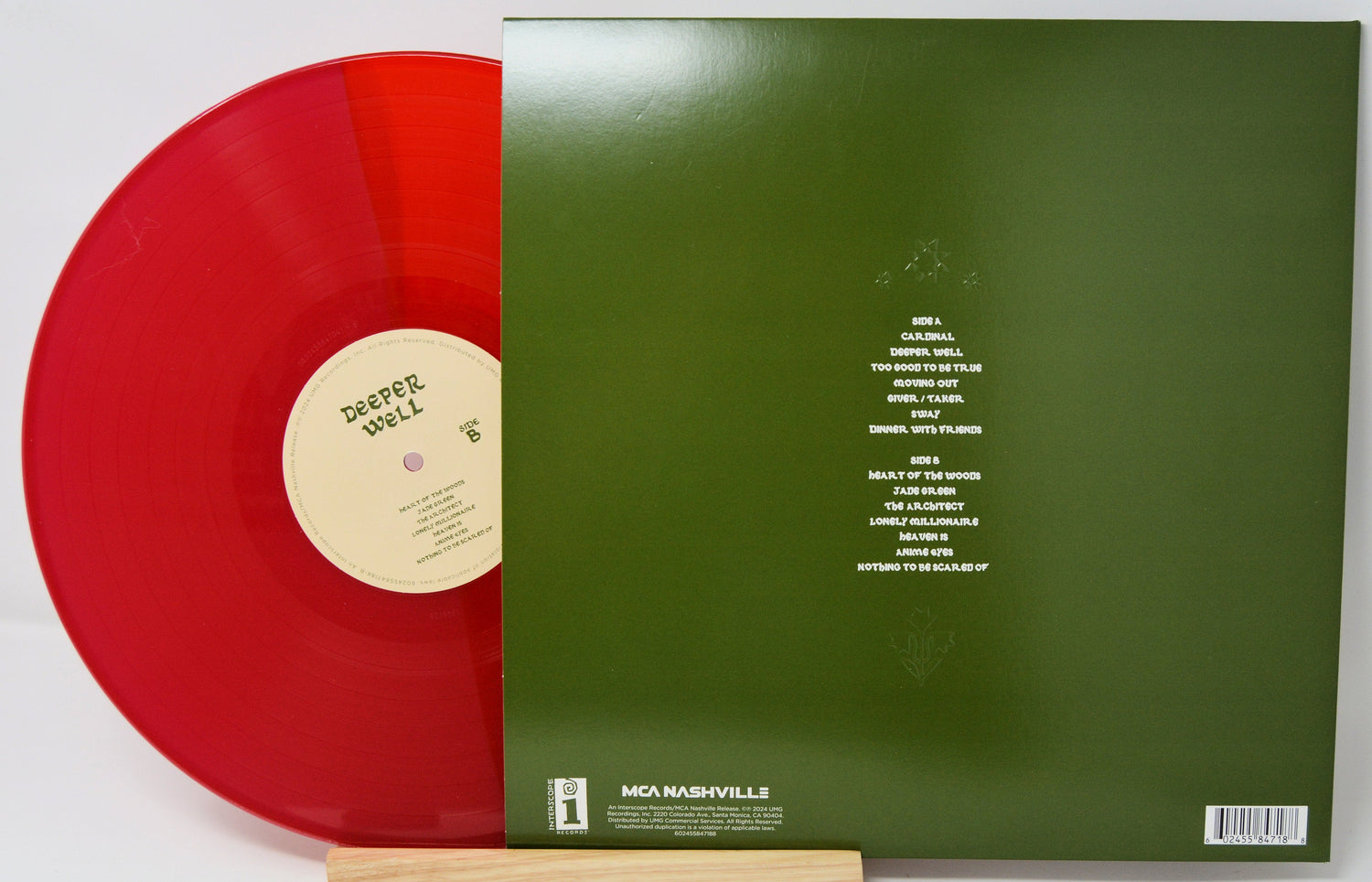Back cover and red vinyl record of Deeper Well by Kacey Musgraves showing tracklist and label