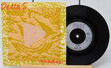 Vinyl record with cover titled 'Shadow' by Delta 5 on a white background