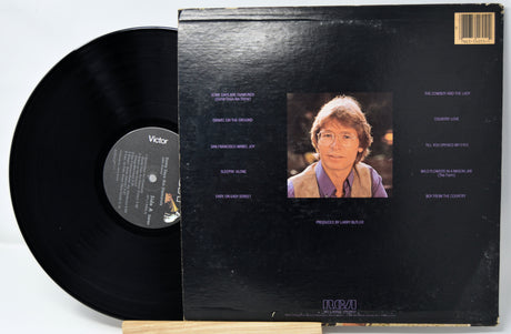 Vinyl record with cover featuring a portrait and text on a white background
