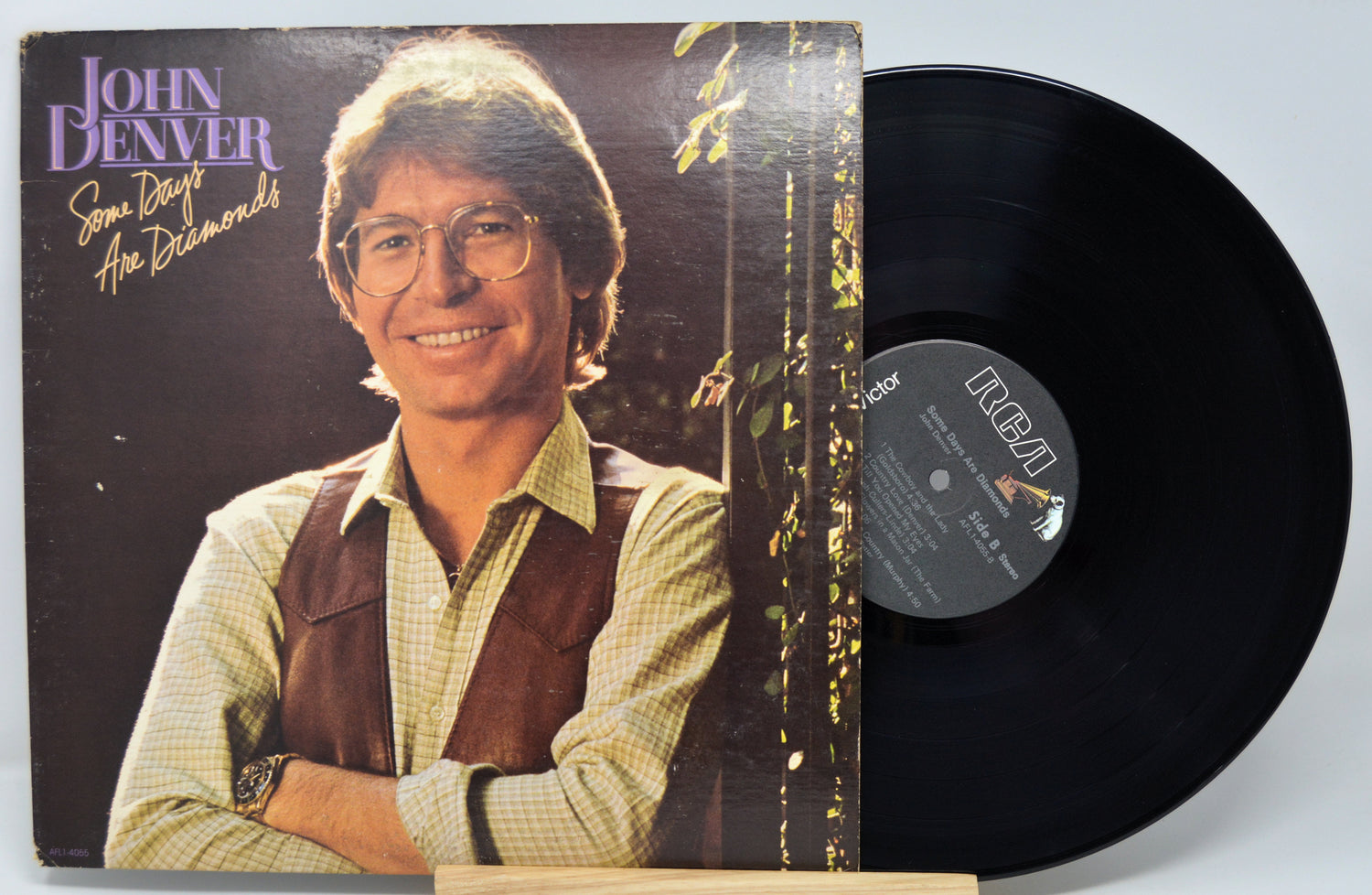 Vinyl record with John Denver album cover showing the artist and album name.