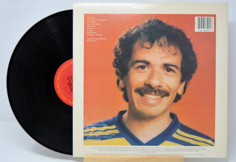 'Devadip Carlos Santana The Swing Of Delight' Vinyl record with a cover featuring a person on an orange background