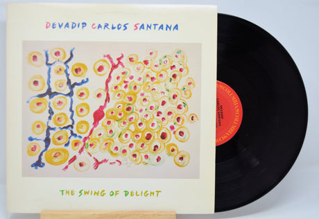 'Devadip Carlos Santana The Swing Of Delight' Vinyl record with a colorful cover featuring abstract designs and text.