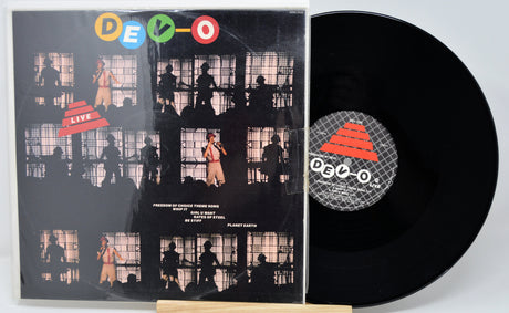 Vinyl record with a black cover featuring silhouettes and a visible DEVO logo.