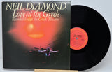 Vinyl record and cover of 'Love at the Greek' by Neil Diamond on a white background