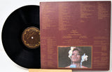 Vinyl record with cover featuring a portrait and text on a white background