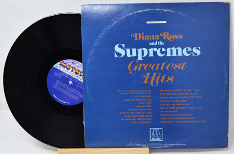 Vinyl record and cover titled 'Diana Ross and the Supremes Greatest Hits' on a white background