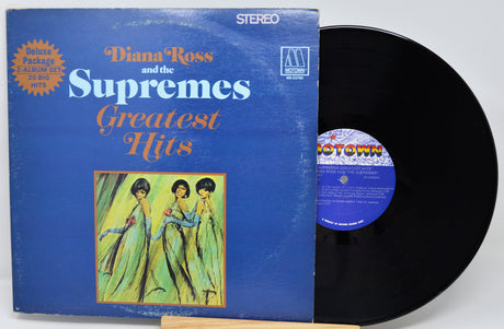 Vinyl record with blue cover featuring 'Diana Ross and the Supremes' and 'Greatest Hits'.