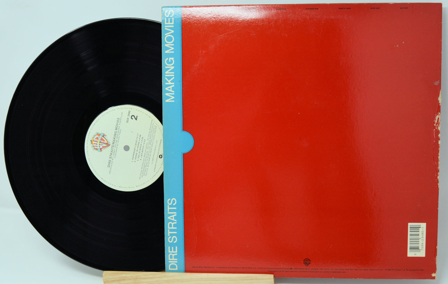Vinyl record with red cover and blue label on a light blue background