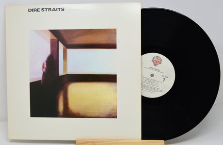 Vinyl record with cover featuring 'Dire Straits' album art on a white background