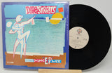 Vinyl record with 'Dire Straits' album cover featuring a dancer illustration.