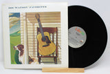 Front cover of Doc Watson Favorites vinyl album with artwork of a guitar on a porch chair and a dog