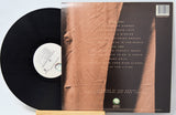 Vinyl record with a brown textured cover and white label on a light gray background