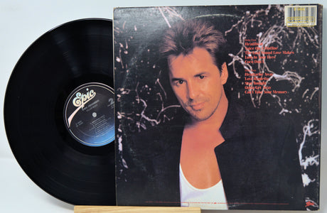 Vinyl record with its cover featuring a person on a light blue background